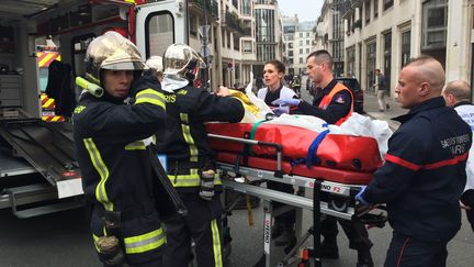 Des pompiers &eacute;vacuent une victime de l'attentat qui a touch&eacute; "Charlie Hebdo", mercredi 7 janvier 2015, dans le 11e arrondissement de Paris. (PHILIPPE DUPEYRAT / AFP)