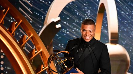 Kylian Mbappé tenant son trophée de meilleur joueur de Ligue 1 lors de la cérémonie des trophées UNFP, le 19 mai 2019 à Paris. (FRANCK FIFE / AFP)