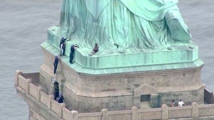 Thérèse Okoumou au pied de la statue de la Liberté, le 4 juillet 2018, pour protester contre la séparation des familles de migrants aux frontières américaines.  (HO / PIX11 NEWS / AFP)