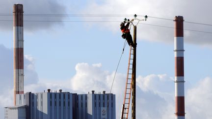 Un technicien d'ERDF r&eacute;pare une ligne &eacute;lectrique endommag&eacute;e apr&egrave;s le passage de la temp&ecirc;te Joachim, le 16 d&eacute;cembre 2011 &agrave; Cordemais (Loire-Atlantique). (FRANK PERRY / AFP)