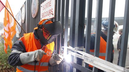 Des employ&eacute;s de l'usine ArcelorMittal de Florange (Moselle) ont soud&eacute; la grille d'entr&eacute;e de l'entreprise pour protester contre la fermeture des deux hauts-fourneaux, annonc&eacute;e lundi 1er octobre 2012.&nbsp; (VINCENT KESSLER / REUTERS)