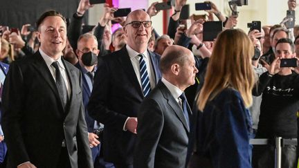 Elon Musk (à gauche) en compagnie d'Olaf Scholz (à droite) lors d'une visite de l'usine Tesla basée en Allemagne, le 22 mars 2022. (PATRICK PLEUL / AFP)