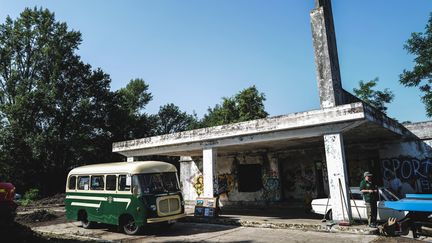 Des membres d'une association d'automobilistes participent aux travaux de restauration d'une ancienne station-service abandonnée des années 1950 le long de l'ancienne route nationale 7 au Coteau, près de Roanne, dans le centre de la France, le 13 août 2021. (OLIVIER CHASSIGNOLE / AFP)