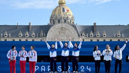 Célébrant sa médaille d'or devant le dôme des Invalides, après l'épreuve de tir à l'arc, le 28 juillet 2024. Le pied ! (PUNIT PARANJPE / AFP)