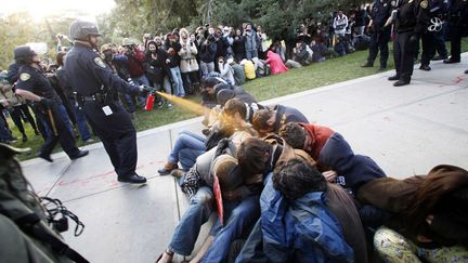 Un policier asperge de gaz au poivre des manifestants appartenant au mouvement Occupy UC Davis sur leur campus en Californie, le 18 novembre 2011. (WAYNE TILCOCK / AP / SIPA)