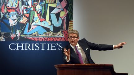 Jussi Pylkkanen, pr&eacute;sident de Christie's New York, vend le tableau de Picasso "Les femmes d'Alger", le 11 mai 2015. (TIMOTHY A. CLARY / AFP)