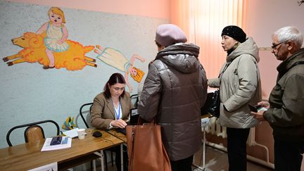 Des Moldaves dans un bureau de vote pour l'élection présidentielle et le referendum sur l'adhésion à l'UE, le 20 octobre 2024. (DANIEL MIHAILESCU / AFP)