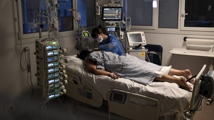 Une infirmière et un patient dans le service de réanimation de l'hôpitale de Créteil (Val-de-Marne), le 28 décembre 2021. (STEPHANE DE SAKUTIN / AFP)