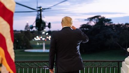 Le président Donald Trump salue l'hélicoptère Marine One depuis la Maison Blanche à son retour le 5 octobre de l'hôpital militaire Walter Reed, où il était hospitalisé après avoir contracté le Covid-19. (EYEPRESS NEWS / AFP)