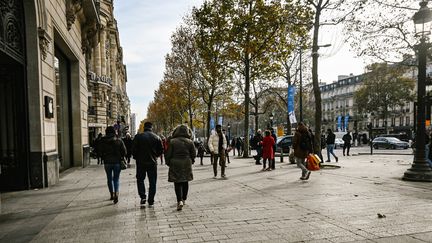 Des passants sur les Champs-Elysées, à Paris, le 15 décembre 2022. (ADRIEN FILLON / HANS LUCAS / AFP)