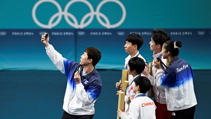 Selfie sur le podium du double mixte en tennis de table aux Jeux olympiques de Paris 2024, le 30 juillet 2024, avec les médaillés sud-coréens, nord-coréens et chinois. Illustration. (WANG ZHAO / AFP)