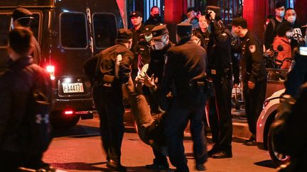 Un homme est arrêté lors d'un ressemblement contre la politique "zéro Covid"&nbsp;à Shanghai (Chine), le 27 novembre 2022.&nbsp; (HECTOR RETAMAL / AFP)