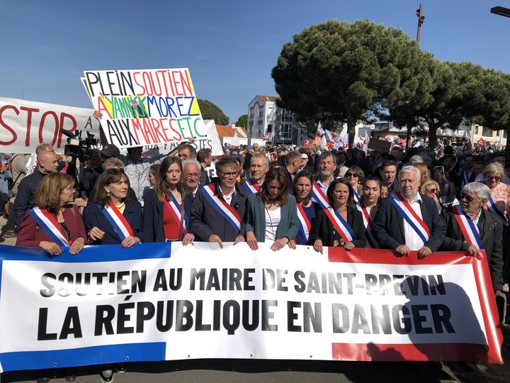 Plusieurs responsables nationaux de gauche marchent côte à côte à Saint-Brevin-le-Pins (Loire-Atlantique), le 24 mai 2023, pour soutenir le maire démissionnaire, Yannick Morez. (RAPHAEL GODET / FRANCEINFO)