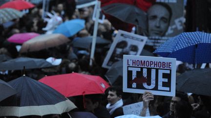 Manifestants sous des parapluies tenant des pancartes avec slogan "l'homophobie tue", en avril 2013.&nbsp; (NATHANAEL CHARBONNIER / FRANCE-INFO)