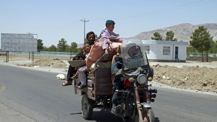 Une famille afghane fuit les combats entre les forces afghanes et les talibans dans la ville d'Herat, le 9 août 2021. (HAMED SARFARAZI / AP / SIPA)