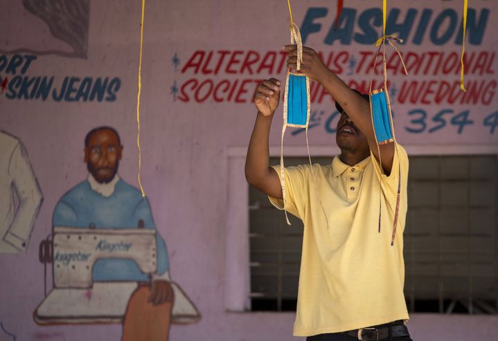 A Diepsloot, au nord de Johannesburg, un commerçant expose, le 16 avril 2020, des masques anti-coronavirus qu'il a fabriqués lui-même. Derrière le commerçant, on lit le mot anglais "fashion", "mode" en français. (THEMBA HADEBE/AP/SIPA / SIPA)