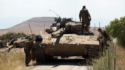 Des soldats isra&eacute;liens pr&egrave;s du point de contr&ocirc;le de Quneitra, &agrave; la fronti&egrave;re avec la Syrie, l&agrave;&nbsp;o&ugrave; un adolescent isra&eacute;lien a &eacute;t&eacute; tu&eacute;, le 22 juin 2014. (MENAHEM KAHANA / AFP)