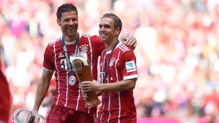 Les joueurs du Bayern Munich Philipp Lahm et Xabi Alonso&nbsp;célèbrent avec une bière leur victoire contre&nbsp;le&nbsp;SC Fribourg, le 20 mai 2017, à Munich en Allemagne. (CHRISTOF STACHE / AFP)