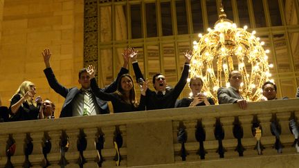 Dans un bar chic, ces mains lev&eacute;es t&eacute;moignent du soutien apport&eacute; par quelques consommateurs aux manifestants dans la gare principale de New York,&nbsp;Grand Central. (TIMOTHY A. CLARY / AFP)