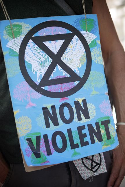 Un militant porte le symbole d'Extinction Rebellion, devant le ministère de la Transition écologique et solidaire à Paris, le 5 juillet 2019. (VINCENT LOISON / SIPA)