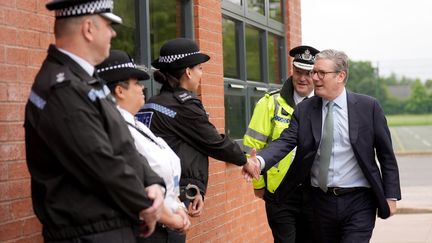 Le Premier ministre britannique, Keir Starmer, salue des policiers à Solihull (Royaume-Uni), le 8 août 2024. (JOE GIDDENS / AFP)