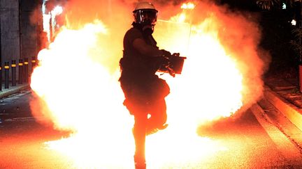 Un cocktail molotov explose pr&egrave;s d'un policier lors d'une manifestation &agrave; Ath&egrave;nes (Gr&egrave;ce), le 25 septembre 2013. (ARIS MESSINIS / AFP)