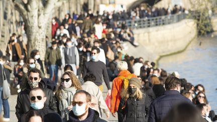 Des Parisiens se promènent sur les quais de Seine, le 7 mars 2021.&nbsp; (JOAO LUIZ BULCAO / HANS LUCAS / AFP)