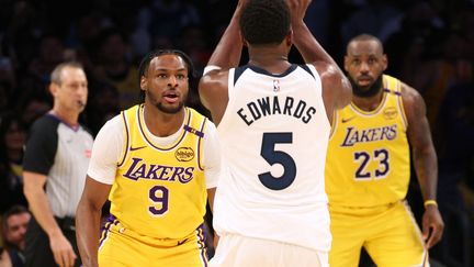 Dans les pas de son père. Pour la première fois de l'histoire de la NBA, un père, LeBron James, et son fils, Bronny, ont foulé les parquets ensemble, contre Minnesota, le 22 octobre. Une première très attendue par les supporters des Lakers, même si Bronny ne montre pas encore le même talent que le "King" James. (HARRY HOW / AFP)