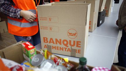 Des bénévoles de la Banque alimentaire prépare des colis, en novembre 2014, à Paris. (ELIOT BLONDET / AFP)