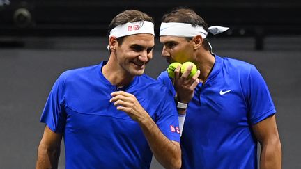 Sourire aux lèvres, Roger Federer reçoit les consignes de son grand rival Rafael Nadal, avant le début de leur double. (GLYN KIRK / AFP)