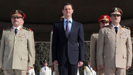 Bachar al-Assad avec son ministre de la D&eacute;fense (&agrave; dr.) et son chef d&eacute;tat-major (&agrave; g.), le 6 octobre 2011 &agrave; Damas (Syrie). (SANA / AFP)