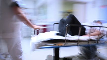 Un infirmier pousse un patient sur un brancard au service des urgences de l'hôpital Emile Muller à Mulhouse, le 16 janvier 2023. Photo d'illustration. (SEBASTIEN BOZON / AFP)