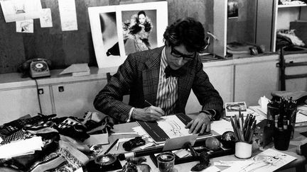 Le couturier Yves Saint Laurent à son bureau en 1976
 (Fondation Pierre Bergé - Yves Saint Laurent Paris photo. Guy Marineau)