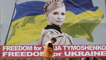 Un balayeur passe devant une affiche repr&eacute;sentant l'opposante Ioulia Timochenko dans les rues de Kiev, le 1er juin 2012. (REUTERS)