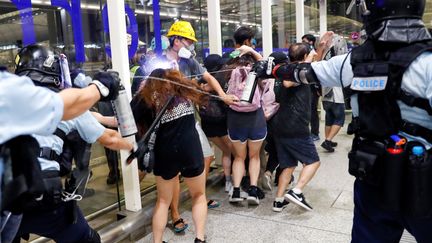 Les forces de l'ordre tentent de disperser des manifestants pro-démocratie, à l'aéroport international de Hong Kong, le 13 août 2019. (TYRONE SIU / REUTERS)