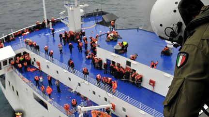 Des passagers du ferry battant pavillon italien, frapp&eacute; dimanche 28 d&eacute;cembre 2014 par un incendie au large des c&ocirc;tes de l'Albanie, en cours d'&eacute;vacuation. (MARINA MILITARE / AFP)