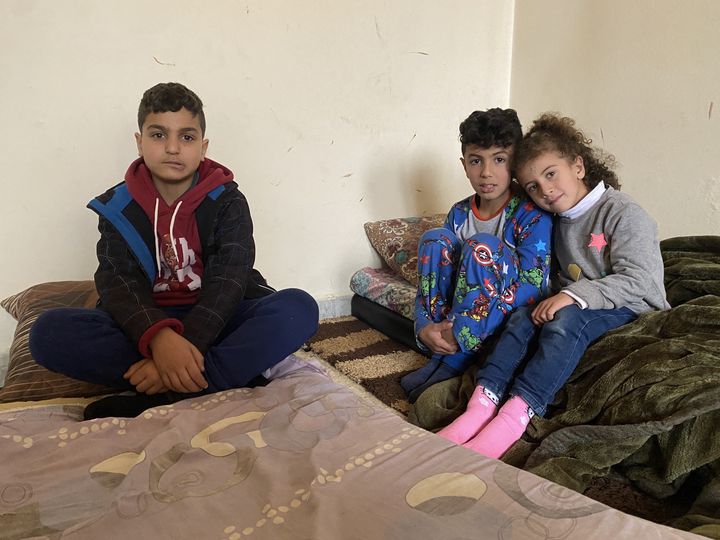 Trois enfants de la famille Dirani se reposent sur des matelas à même le sol, le 10 janvier 2024 à Qmatiye (Liban). (RAPHAEL GODET / FRANCEINFO)