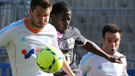 Les Marseillais Andr&eacute;-Pierre Gignac, &agrave; gauche, et amthieu Valbuena, &agrave; droite, encadre le Toulousain Serge Aurier, lors de la victoire de l'OM 2-1 contre le TFC, dimanche 11 mai 2013 &agrave; Marseille. (BORIS HORVAT / AFP)