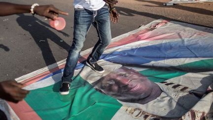 2 décembre 2016. Au lendemain de la présidentielle en Gambie, un supporter du président élu, Adama Barrow, piétine à Serekunda un portrait de Yahya Jammeh qui a reconnu sa défaite après 22 ans de règne. (MARCO LONGARI/AFP)