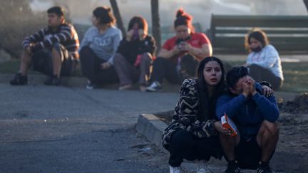 Des habitants de la station balnéaire de Vina del Mar se consolent après des incendies dévastateurs ayant frappé la ville et sa région, le 3 février 2024. (LUCAS AGUAYO ARAOS / ANADOLU / AFP)