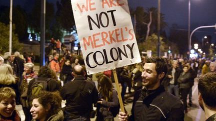 Manifestation à Athènes, après la décision de la BCE sur le financement des banques grecques. «Nous ne sommes pas une colonie de Merkel», dit la pancarte.  (LOUISA GOULIAMAKI / AFP)