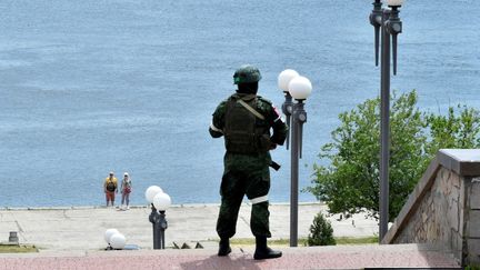 Un soldat russe patrouille sur la rive d'une rivière à Kherson (Ukraine), le 20 mai 2022. (OLGA MALTSEVA / AFP)