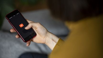 Un utilisateur ouvre l'application YouTube sur son smartphone, le 24 avril 2021, à Berlin (Allemagne). (FABIAN SOMMER / DPA / AFP)