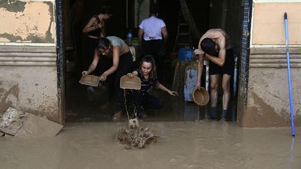 Des habitants nettoient leur maison, à La Torre, près de Valence. (JOSE JORDAN / AFP)