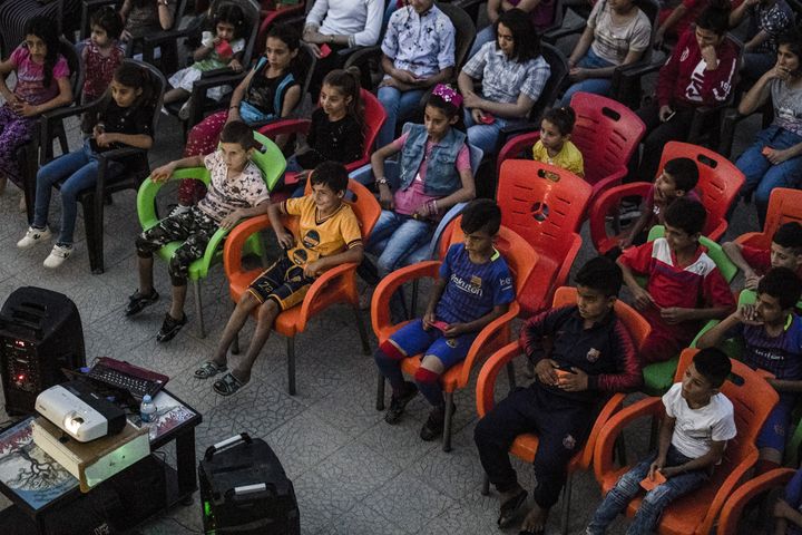 Les enfants profitent d'une séance de cinéma grâce au cinéma itinérant du réalisateur Shero Hinde.&nbsp; (DELIL SOULEIMAN / AFP)