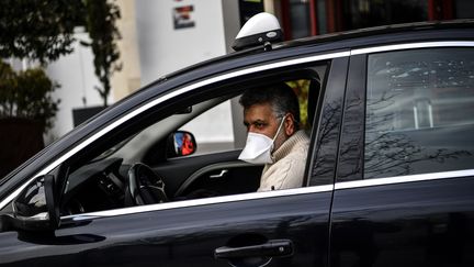 Un chauffeur de taxi attend des clients devant la gare d'Austerlitz à Paris, le 17 mars 2020 (photo d'illustration). (CHRISTOPHE ARCHAMBAULT / AFP)