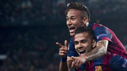 Des joueurs du FC Barcelone, Neymar sur les &eacute;paules de Dani Alves, c&eacute;l&egrave;brent un but face au PSG lors du quart de finale retour de la Ligue des Champions, &agrave; Barcelone (Espagne), le 21 avril 2015. (JOSEP LAGO / AFP)