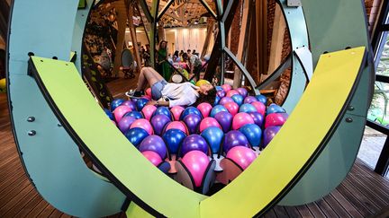 Une femme allongée sur une installation créée par la société de design espagnole Finsa le 9 juin 2022, lors du Salon du design à Milan. (MIGUEL MEDINA / AFP)