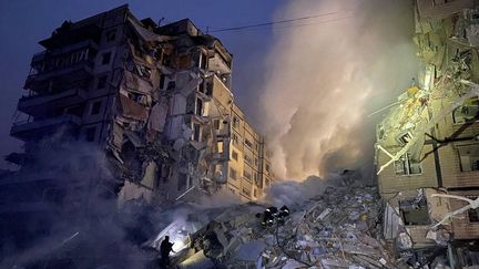 Les secours interviennent dans les ruines d'une résidence à Dnipro (Ukraine), après que l'édifice a été ravagé par une frappe, le 14 janvier 2023. (AFP)