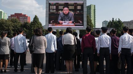 Des Nord-Coréens regardent le dirigeant&nbsp;Kim Jong-un sur un écran télévisé sur une place de Pyongyang, le 22 septembre 2017. (ED JONES / AFP)